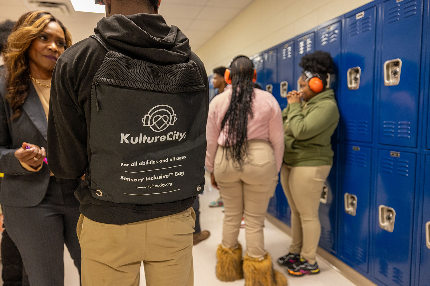 Boy wearing a KultureCity bag talking to a woman